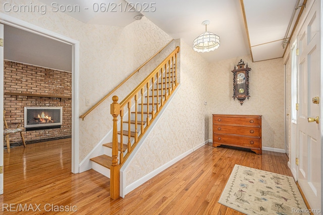 1925 Dawn Ridge Rd, Commerce Twp, MI 48390 - stairs with hardwood / wood-style flooring, wallpapered walls, and a fireplace