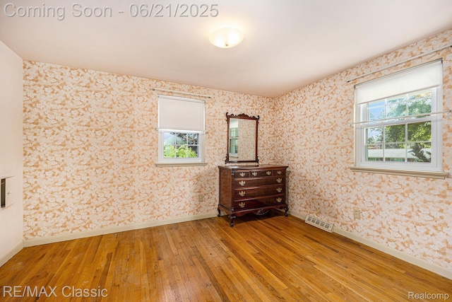 1925 Dawn Ridge Rd, Commerce Twp, MI 48390 - spare room with light wood-style floors, healthy amount of natural light, and wallpapered walls