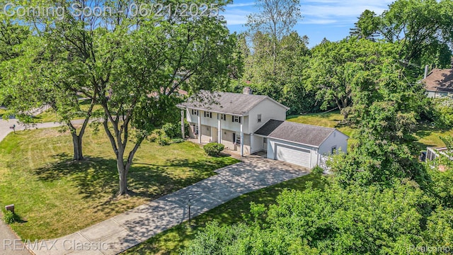 1925 Dawn Ridge Rd, Commerce Twp, MI 48390 - view of front of home featuring a porch, concrete driveway, a front yard, an attached garage, and a chimney