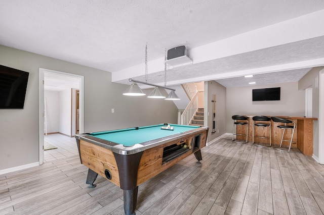 13421 Woodland Ct, Big Rapids, MI 49307 - playroom featuring light wood-type flooring, billiards, bar, and a textured ceiling