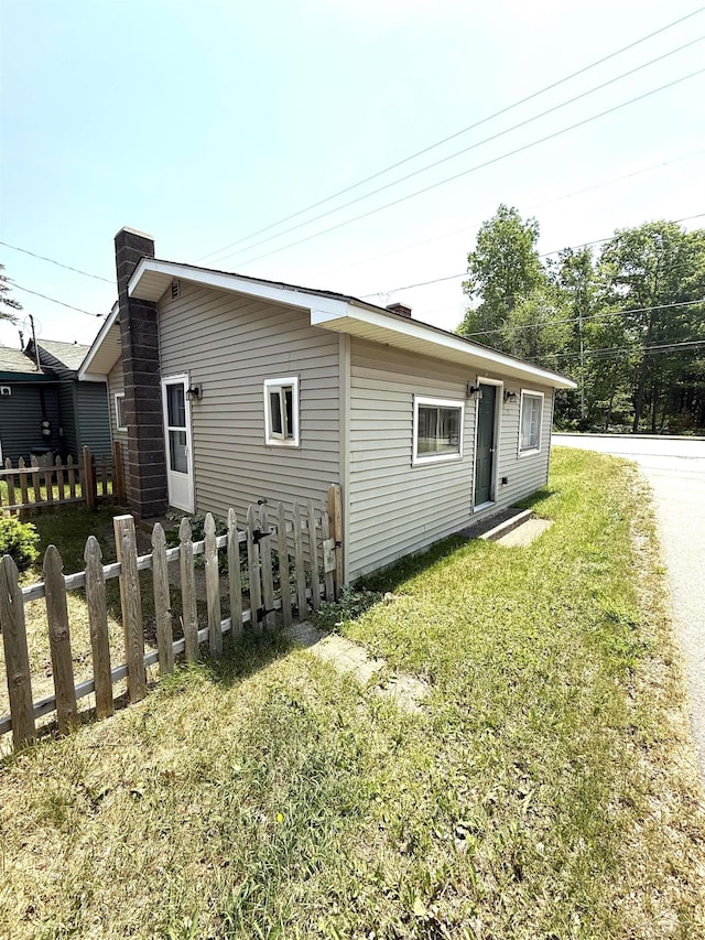 578 W Houghton Lake Dr, Prudenville, MI 48651 - view of side of home featuring a chimney