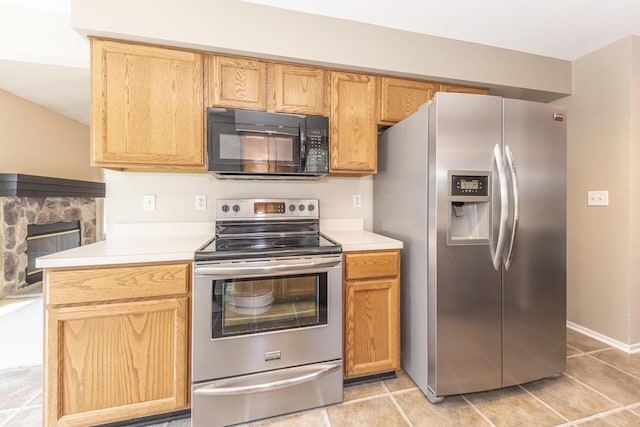 492 Colin Cir, Ann Arbor, MI 48103 - kitchen featuring appliances with stainless steel finishes, light countertops, a fireplace, and light tile patterned flooring