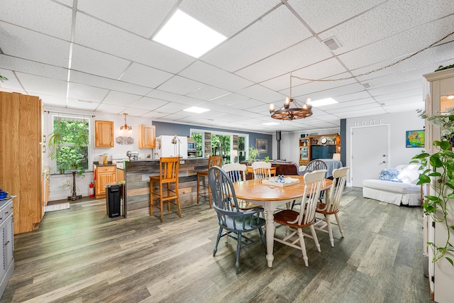 283 W 16th St, Baldwin, MI 49304 - dining area featuring wood finished floors, a chandelier, and a drop ceiling
