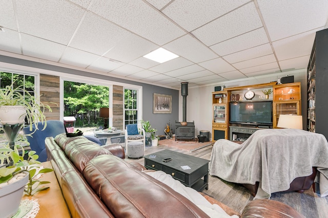283 W 16th St, Baldwin, MI 49304 - living room with a wood stove, healthy amount of natural light, a paneled ceiling, and wood finished floors