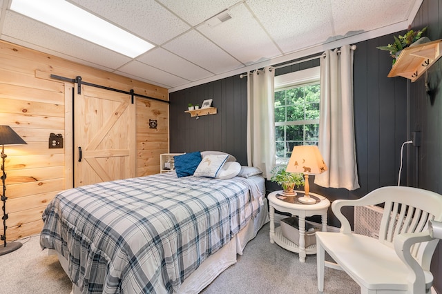 283 W 16th St, Baldwin, MI 49304 - bedroom with carpet floors, a barn door, wood walls, and a paneled ceiling