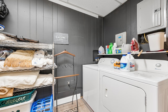 283 W 16th St, Baldwin, MI 49304 - laundry area featuring washing machine and clothes dryer, light wood-type flooring, and wooden walls