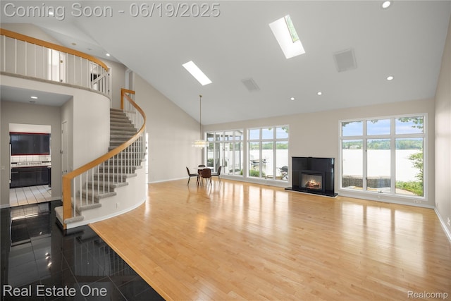 2505 Cedar Key Dr, Lake Orion, MI 48360 - unfurnished living room with high vaulted ceiling, stairway, a glass covered fireplace, a skylight, and recessed lighting
