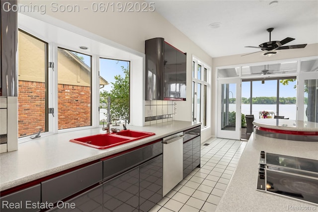 2505 Cedar Key Dr, Lake Orion, MI 48360 - kitchen with stainless steel dishwasher, light tile patterned floors, a ceiling fan, light countertops, and a water view
