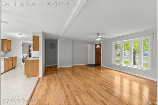 36513 Evans St, New Boston, MI 48164 - unfurnished living room with washing machine and dryer, ceiling fan, and light wood finished floors