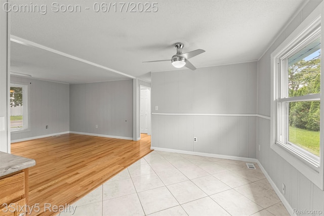 36513 Evans St, New Boston, MI 48164 - unfurnished room featuring healthy amount of natural light, ceiling fan, a textured ceiling, wood finished floors, and wooden walls