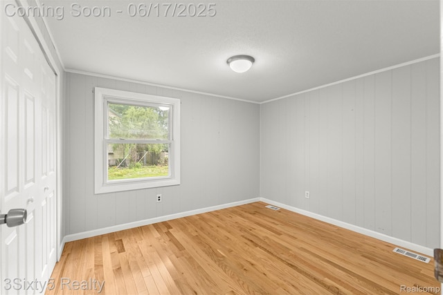 36513 Evans St, New Boston, MI 48164 - spare room featuring light wood-style floors and crown molding
