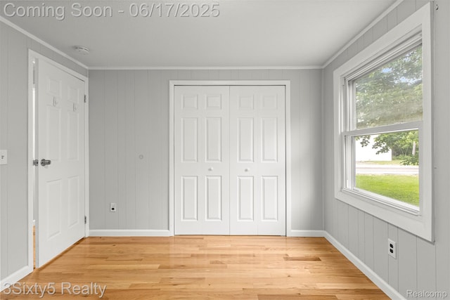 36513 Evans St, New Boston, MI 48164 - unfurnished bedroom featuring light wood-style flooring, crown molding, multiple windows, and a closet