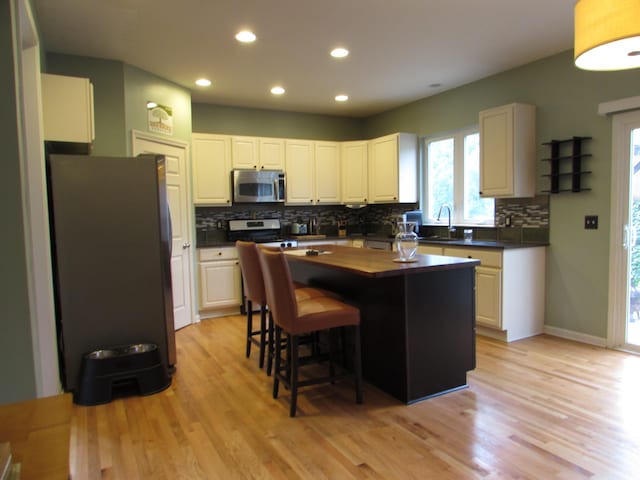 1995 Frances Way, Ypsilanti, MI 48198 - kitchen with appliances with stainless steel finishes, tasteful backsplash, recessed lighting, light wood-type flooring, and a center island