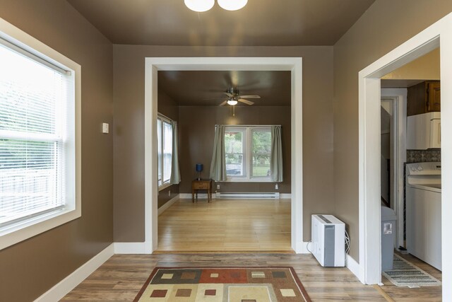 318 Cecil St, Buchanan, MI 49107 - hall featuring washer / dryer, a baseboard heating unit, and light wood-type flooring