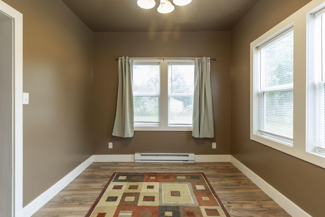 318 Cecil St, Buchanan, MI 49107 - empty room with a baseboard radiator, wood finished floors, and a chandelier