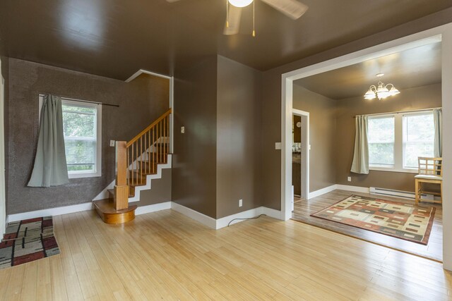 318 Cecil St, Buchanan, MI 49107 - entryway featuring wood finished floors, stairway, ceiling fan, a chandelier, and baseboard heating
