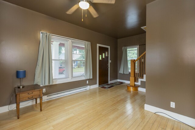 318 Cecil St, Buchanan, MI 49107 - foyer featuring a baseboard heating unit, a ceiling fan, wood finished floors, and stairs