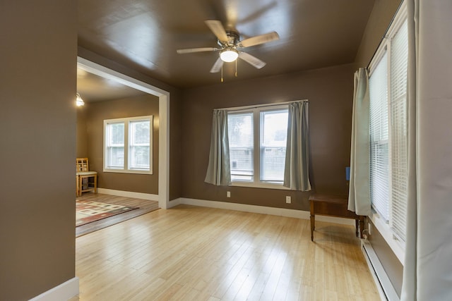 318 Cecil St, Buchanan, MI 49107 - empty room featuring a ceiling fan, wood finished floors, and a baseboard heating unit