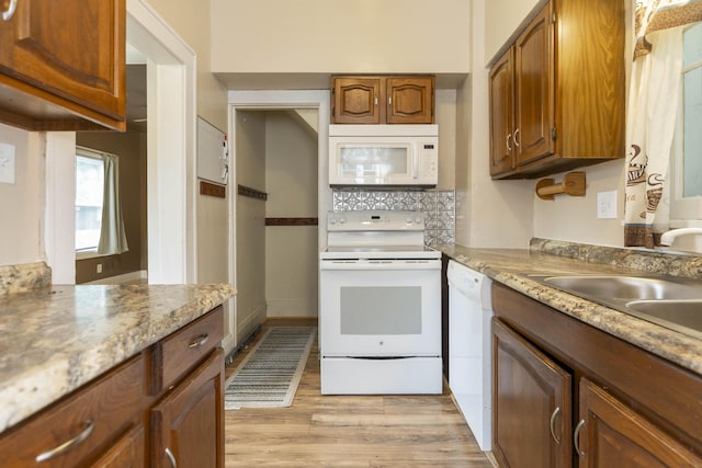 318 Cecil St, Buchanan, MI 49107 - kitchen with white appliances, light wood-type flooring, brown cabinetry, and backsplash