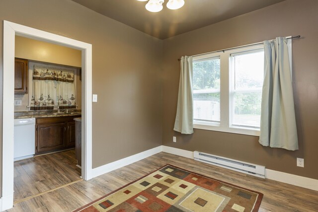 318 Cecil St, Buchanan, MI 49107 - spare room featuring a baseboard radiator, wood finished floors, and a chandelier