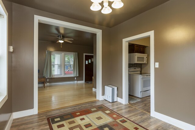 318 Cecil St, Buchanan, MI 49107 - hall with a baseboard heating unit, light wood-style flooring, and a chandelier