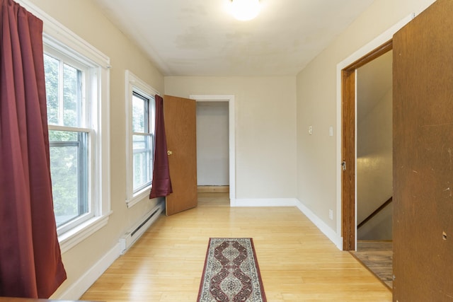 318 Cecil St, Buchanan, MI 49107 - unfurnished room featuring a baseboard radiator, plenty of natural light, and light wood-style floors