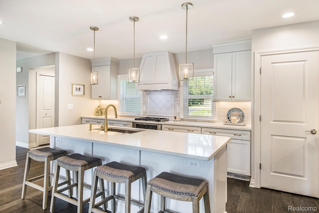 22085 Thorofare Rd, Grosse Ile, MI 48138 - kitchen with premium range hood, backsplash, dark wood-style floors, light countertops, and a breakfast bar
