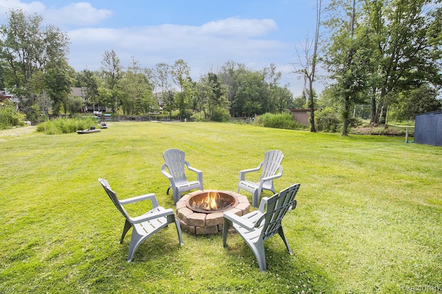 22085 Thorofare Rd, Grosse Ile, MI 48138 - view of green lawn with an outdoor fire pit and view of wooded area