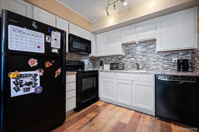 17013 Smugglers Cove St, Clinton Township, MI 48038 - kitchen with black appliances, white cabinetry, backsplash, light wood-style floors, and light stone countertops