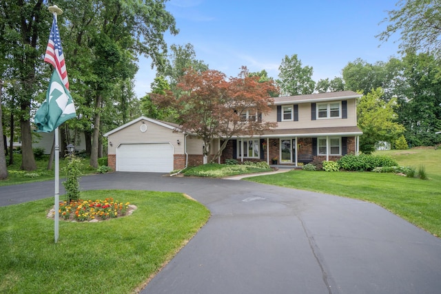 3125 Fawn Ln, Jackson, MI 49201 - view of front of property featuring driveway, a front lawn, a garage, brick siding, and covered porch