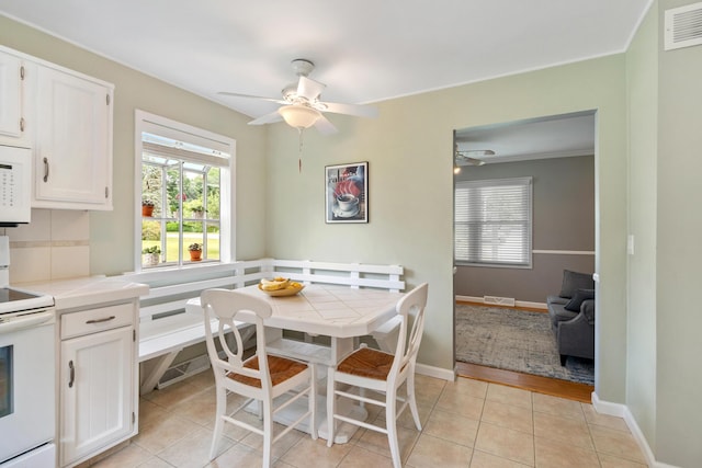 3125 Fawn Ln, Jackson, MI 49201 - dining area with a ceiling fan, healthy amount of natural light, light tile patterned floors, and crown molding