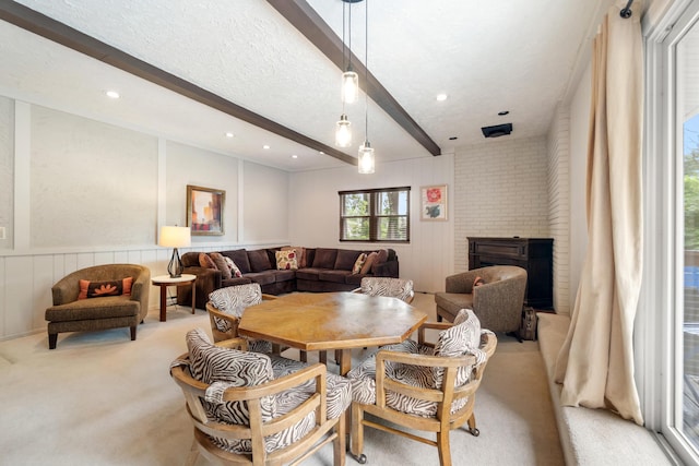 3125 Fawn Ln, Jackson, MI 49201 - dining space featuring beam ceiling, carpet, a decorative wall, a brick fireplace, and a wainscoted wall