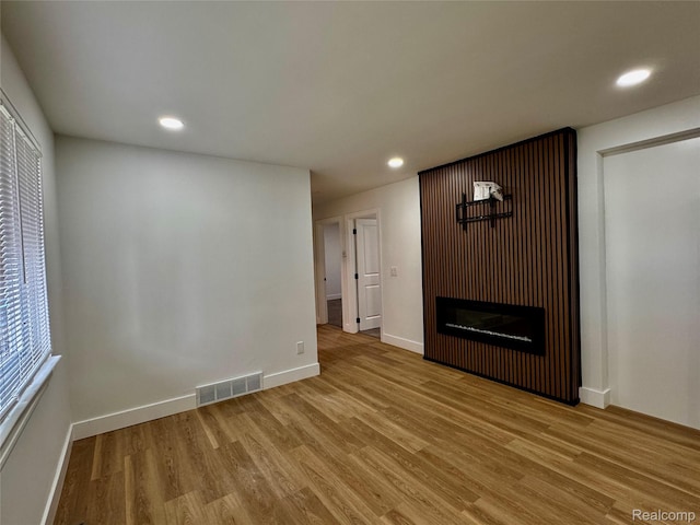 297 W Yale Ave, Pontiac, MI 48340 - unfurnished living room featuring light wood-style flooring, recessed lighting, and a glass covered fireplace