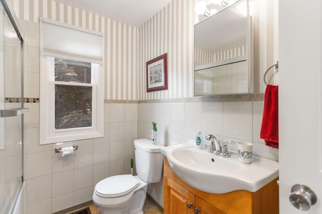 317 Cherry St, South Haven, MI 49090 - full bath with wallpapered walls, vanity, a wainscoted wall, combined bath / shower with glass door, and tile walls