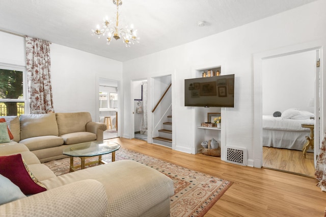 317 Cherry St, South Haven, MI 49090 - living room featuring a chandelier, wood finished floors, and stairway