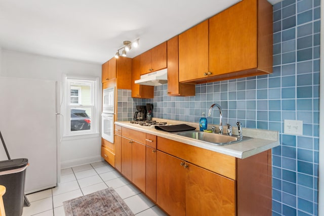 317 Cherry St, South Haven, MI 49090 - kitchen featuring under cabinet range hood, white appliances, light countertops, light tile patterned flooring, and tasteful backsplash