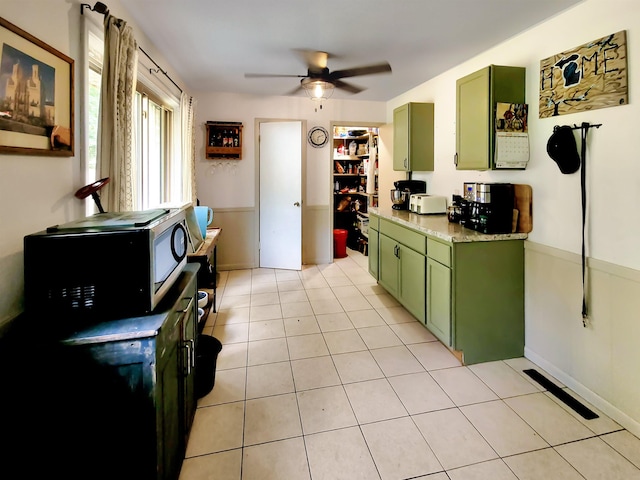 424 Leland St, Flushing, MI 48433 - kitchen with green cabinets, ceiling fan, black microwave, light countertops, and light tile patterned flooring