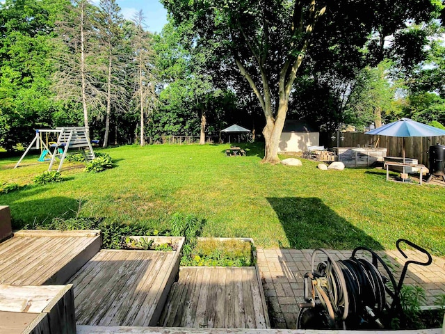 424 Leland St, Flushing, MI 48433 - fenced backyard featuring a shed, a playground, and a deck