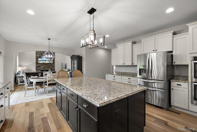 966 Wynstone Cir N, Oakland, MI 48363 - kitchen with appliances with stainless steel finishes, a chandelier, arched walkways, white cabinetry, and light wood-style floors