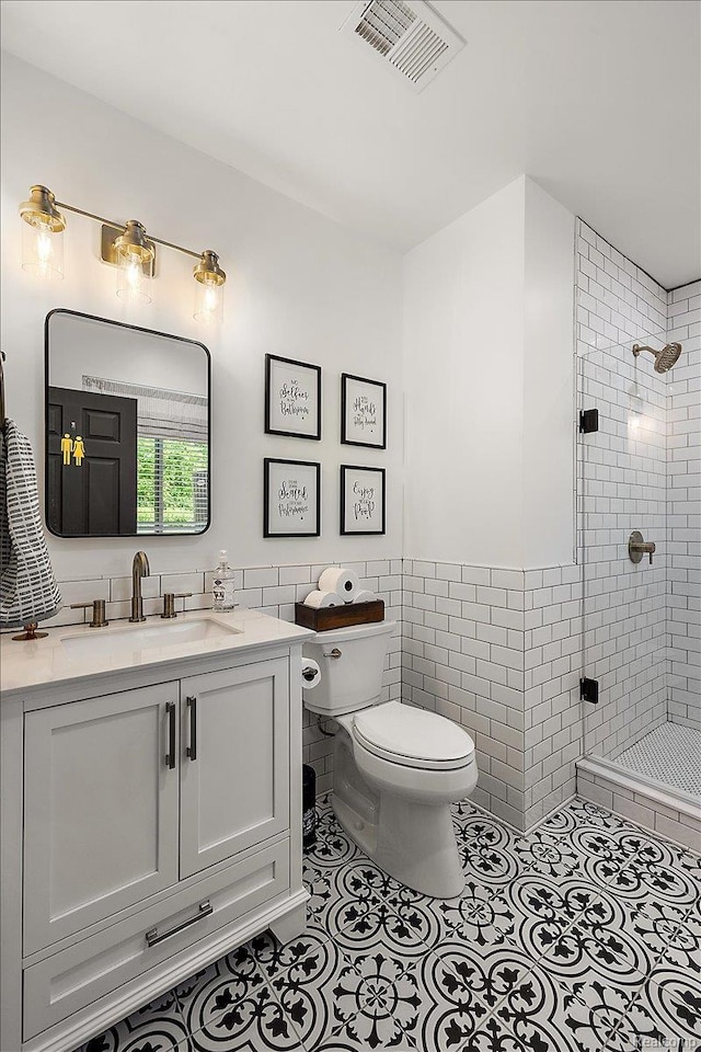 966 Wynstone Cir N, Oakland, MI 48363 - bathroom with tile walls, a stall shower, vanity, tile patterned floors, and a wainscoted wall