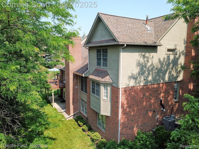 1070 Pointe Place Ct, Rochester, MI 48307 - view of side of property with a shingled roof, a deck, brick siding, and a yard