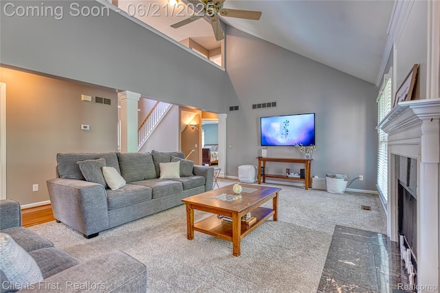 1070 Pointe Place Ct, Rochester, MI 48307 - carpeted living area with decorative columns, high vaulted ceiling, a ceiling fan, a fireplace with flush hearth, and stairway