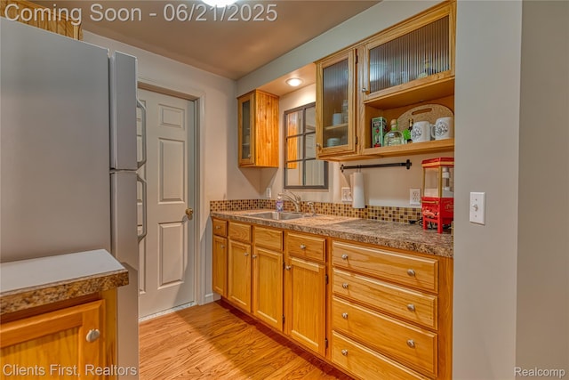 1070 Pointe Place Ct, Rochester, MI 48307 - kitchen featuring freestanding refrigerator, light wood-type flooring, decorative backsplash, glass insert cabinets, and brown cabinets