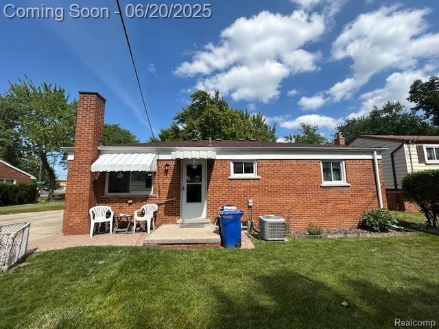 30821 Longfellow Ave, Madison Heights, MI 48071 - rear view of property with a chimney, a lawn, brick siding, and a patio area