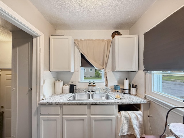 20115 Pelkey St, Detroit, MI 48205 - kitchen with a textured ceiling, decorative backsplash, and white cabinets