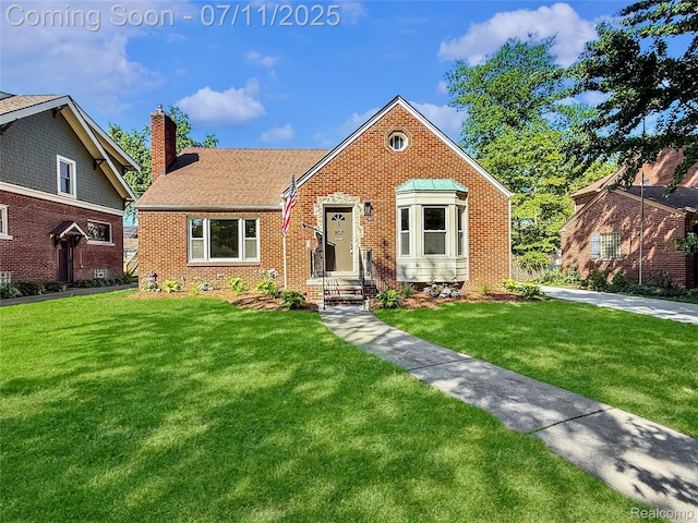 807 Barrington Rd, Grosse Pointe Park, MI 48230 - view of front facade with a chimney, a front lawn, brick siding, and roof with shingles