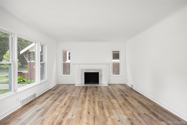 807 Barrington Rd, Grosse Pointe Park, MI 48230 - unfurnished living room with plenty of natural light, light wood finished floors, and a fireplace