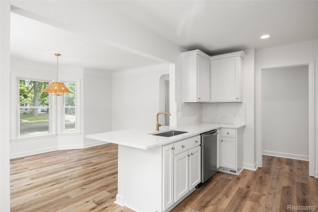 807 Barrington Rd, Grosse Pointe Park, MI 48230 - kitchen featuring stainless steel dishwasher, a peninsula, white cabinets, light wood-style flooring, and decorative light fixtures