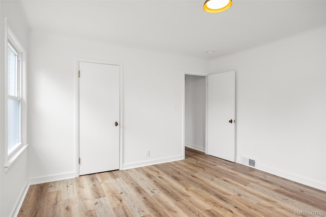 807 Barrington Rd, Grosse Pointe Park, MI 48230 - unfurnished bedroom with wood finished floors and multiple windows