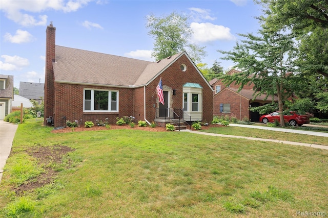 807 Barrington Rd, Grosse Pointe Park, MI 48230 - view of front facade with brick siding, a chimney, a front lawn, and a shingled roof